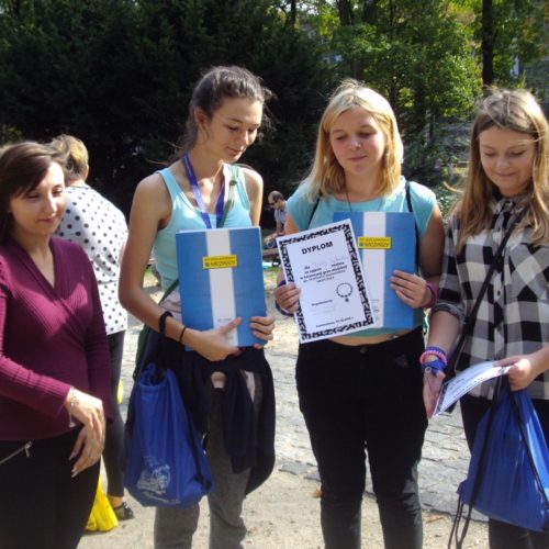 Zdjęcie przedstawiające cztery uczestniczki gry miejskiej "Tajemnica skradzionego naszyjnika" trzymające dyplom