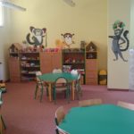 Zdjęcie przedstawiające kącik dla dzieci z nowymi stolikami, regałami, wykładziną i pomalowanymi ścianami z ozdobami na filii nr 14